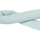 Die KraftKids GmbH Wickeltischrolle Musselin mint Pusteblumen ist ein hellblaues, langes und biegsames Kissen mit dezentem weißem Pusteblumenmuster, das sich vor weißem Hintergrund zu einem lockeren Knoten verdreht.