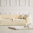 Eine gemütliche Couch im Zimmer, ergänzt durch die KraftKids Krabbeldecke Musselin Zweige braun, mit weichem Polyestervlies für zusätzlichen Komfort.