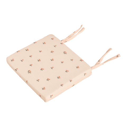 Das KraftKids Sitzkissen für Stühle aus Musselin ist ein quadratisches, hellbeiges Kissen mit kleinem rosa Blumendruck und zwei Paar Stoffbändern. Es hat einen abnehmbaren Bezug und ist auf einem weißen Hintergrund abgebildet.