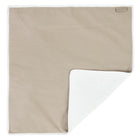 Die KraftKids Wickelunterlage Musselin beige ist eine rechteckige Wickelunterlage aus Musselin in Hellbeige mit einem weichen weißen Innenfutter. Eine Ecke ist gefaltet, um das Innere zu zeigen - perfekt als wasserdichte Wickelunterlage. Ein Stoffetikett akzentuiert den Rand.