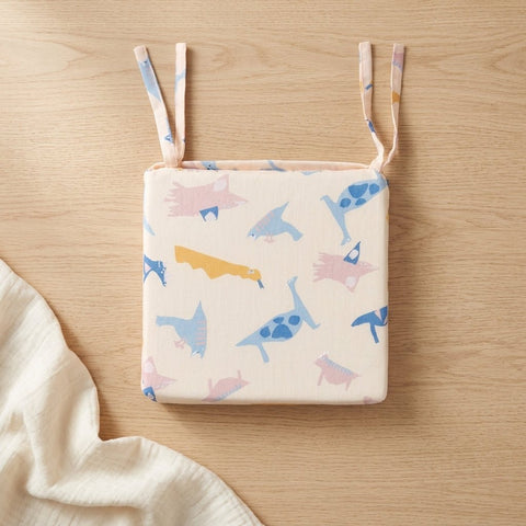 Das KraftKids Sitzkissen für Stühle aus Musselin verfügt über ein verspieltes, pastellfarbenes Dinosaurier-Design, Bindebänder und einen abnehmbaren Bezug für eine einfache Reinigung - ideal als stylisches und praktisches Sitzkissen Esszimmer-Accessoire.