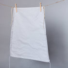 Der KraftKids Sonnensegel weiße Punkte auf Grau, ein hellgrauer Kinderwagen-Sonnenschirm mit kleinen weißen Punkten, hängt an einer Wäscheleine vor einem einfarbig grauen Hintergrund.