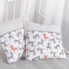 Zwei KraftKids Kissenbezug kleine Rehkitze grau orange auf Weiß ruhen auf einer grauen Decke mit verspieltem Hirschmuster. Ein weißes Kinderbett und transparente Vorhänge im Hintergrund verleihen Ihrer Bettwäschesammlung Charme.