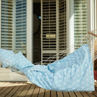 Ein KraftKids Bettwäscheset "weiße Diamante auf Pastell Blau" lädt mit seinem frischen Muster und 100% Baumwolle zu erholsamem Schlaf ein - wie Sonnenstrahlen auf einer blauen Veranda.