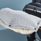 Der Kinderwagenmuff Musselin grau Pusteblumen von KraftKids ist mit weichem Fleece gefüttert und hat ein weißes Pusteblumenmotiv. Er lässt sich ganz einfach am Kinderwagengriff befestigen und hält die Hände bei jedem Spaziergang angenehm warm.