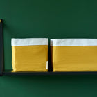 Ein schwarzes Regal mit KraftKids Körbchen Doppelkrepp Gelb Mustard Boxen, perfekt für die Organisation von Essentials über Ihrem Wickeltisch.