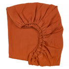 KraftKids Spannbettlaken Doppelkrepp Rot Herbstrot aus 100% Baumwolle mit gesäumtem Gummizug, teilweise gefaltet auf weißem Hintergrund.