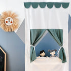 Das KraftKids Puppentheater Kasperletheater Doppelkrepp Grün Jade mit Teleskopstange hängt an einer blau-grauen Wand. Zwei Handpuppen, eine Sonne und eine bunte Kreidetafel ergänzen die Szene.