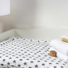 Der KraftKids Wickeltisch-Aufsatz für LOMMARP schmall ist ein weißer Wickeltisch, der für sicheres und bequemes Wickeln mit elegantem Stil und einfacher Montage entwickelt wurde. Oben drauf: Sternchenmatte, gefaltete Handtücher, Holzbehälter, Babybürste; daneben steht eine Stehlampe.